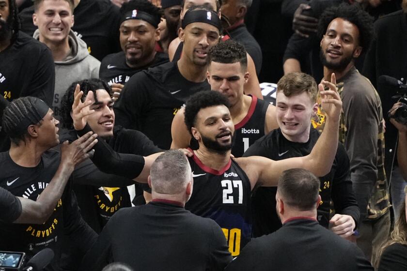 Denver Nuggets guard Jamal Murray (27) is congratulated by teammates after hitting the game-winning basket at the buzzer against the Los Angeles Lakers during the second half in Game 2 of an NBA basketball first-round playoff series Monday, April 22, 2024, in Denver. (AP Photo/Jack Dempsey)