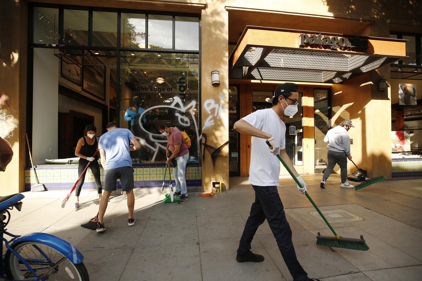 People clean up on 4th Street in Santa Monica on Monday.