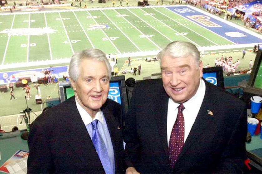 Legendary football broadcaster Pat Summerall, left, pictured with with John Madden in the broadcast booth before Super Bowl XXXVI on Feb. 3, 2002, has died. He was 82.