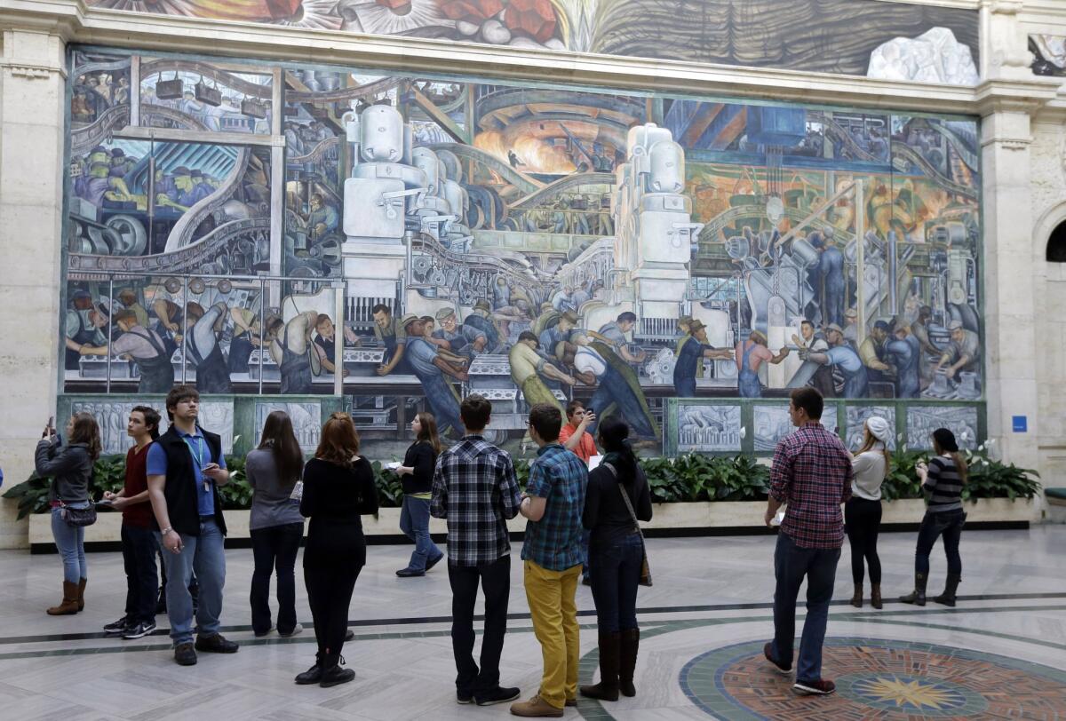 Visitors gather in front of the Detroit Industry Murals by Diego Rivera at the Detroit Institute of Arts.