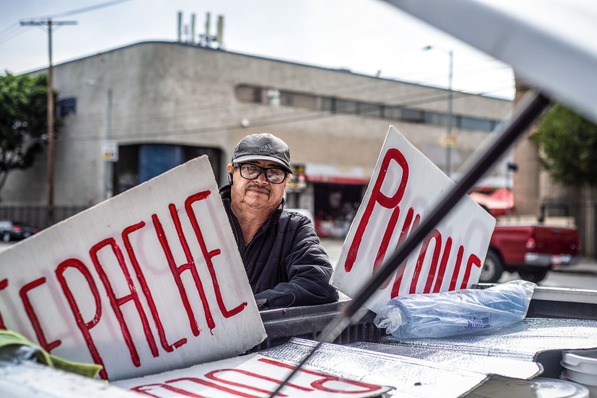 A man with signs that read "tepache" and "pulque."