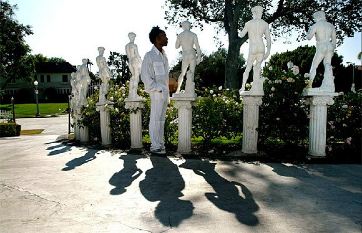 Miniature statues of Michelangelo's David curve along the front lawn of Norwood Young's home.