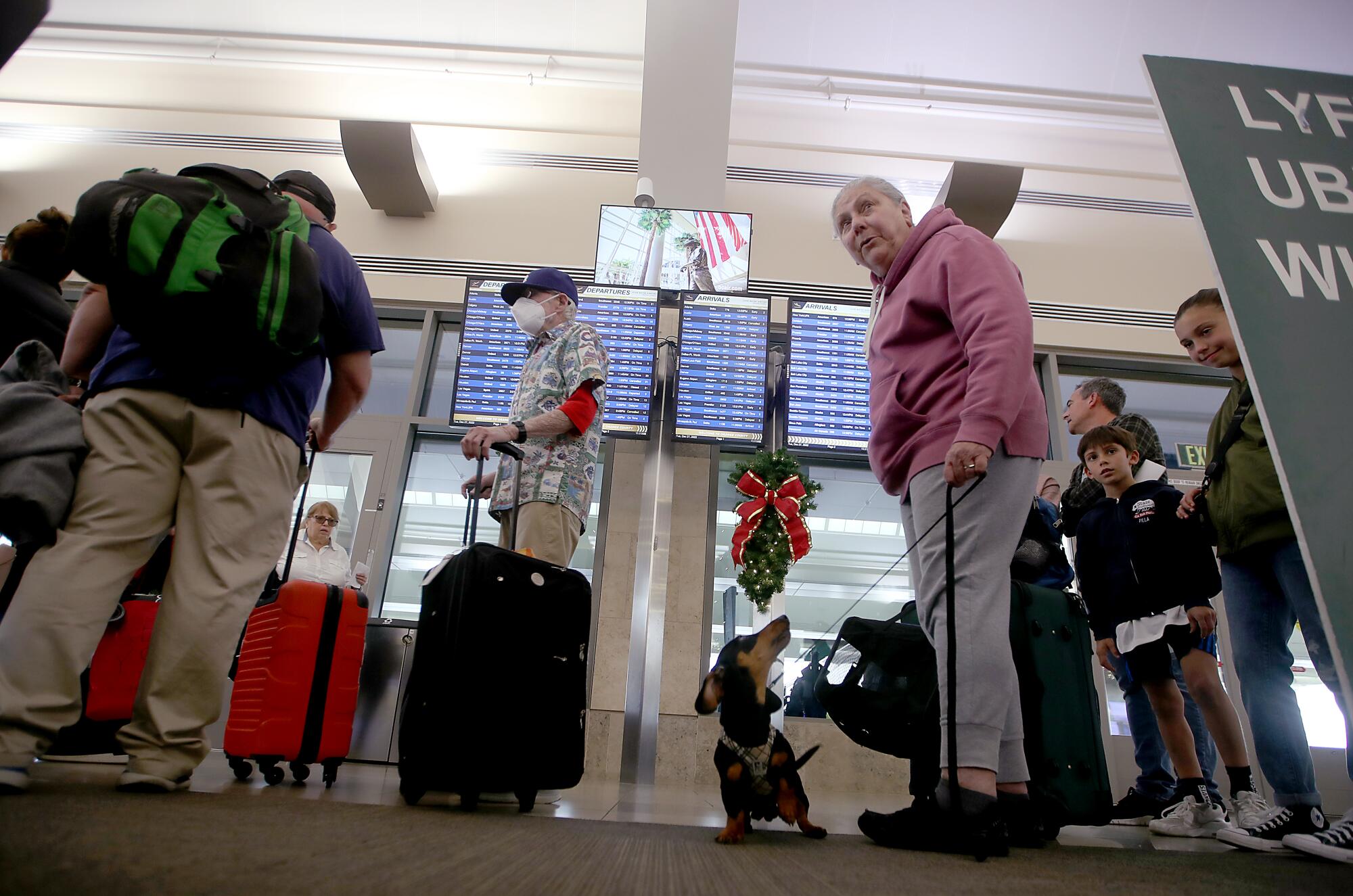 Stephanie Commerford and her dog, Pickle, wait in line at the Southwest Airlines terminal at John Wayne Airport 