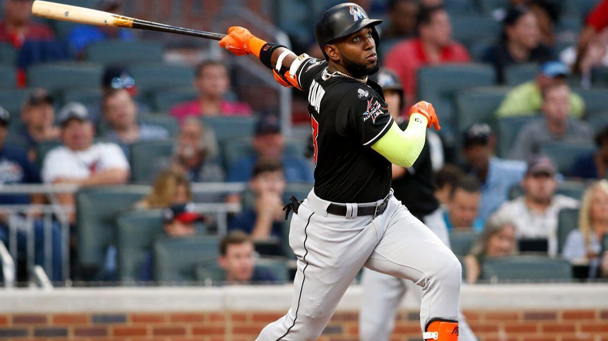 Marcell Ozuna watches his RBI triple during the first inning of a game between the Miami Marlins and Atlanta Braves on Sept. 7.