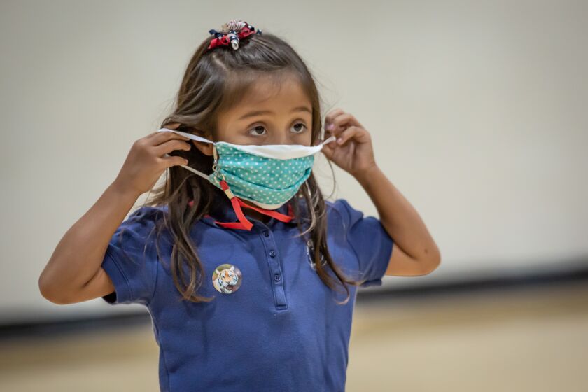 EL CAJON, CA - AUGUST 24: Second grader, Julia puts her mask on during gym class on Monday, Aug. 24, 2020 in El Cajon, CA. (Jarrod Valliere / The San Diego Union-Tribune)