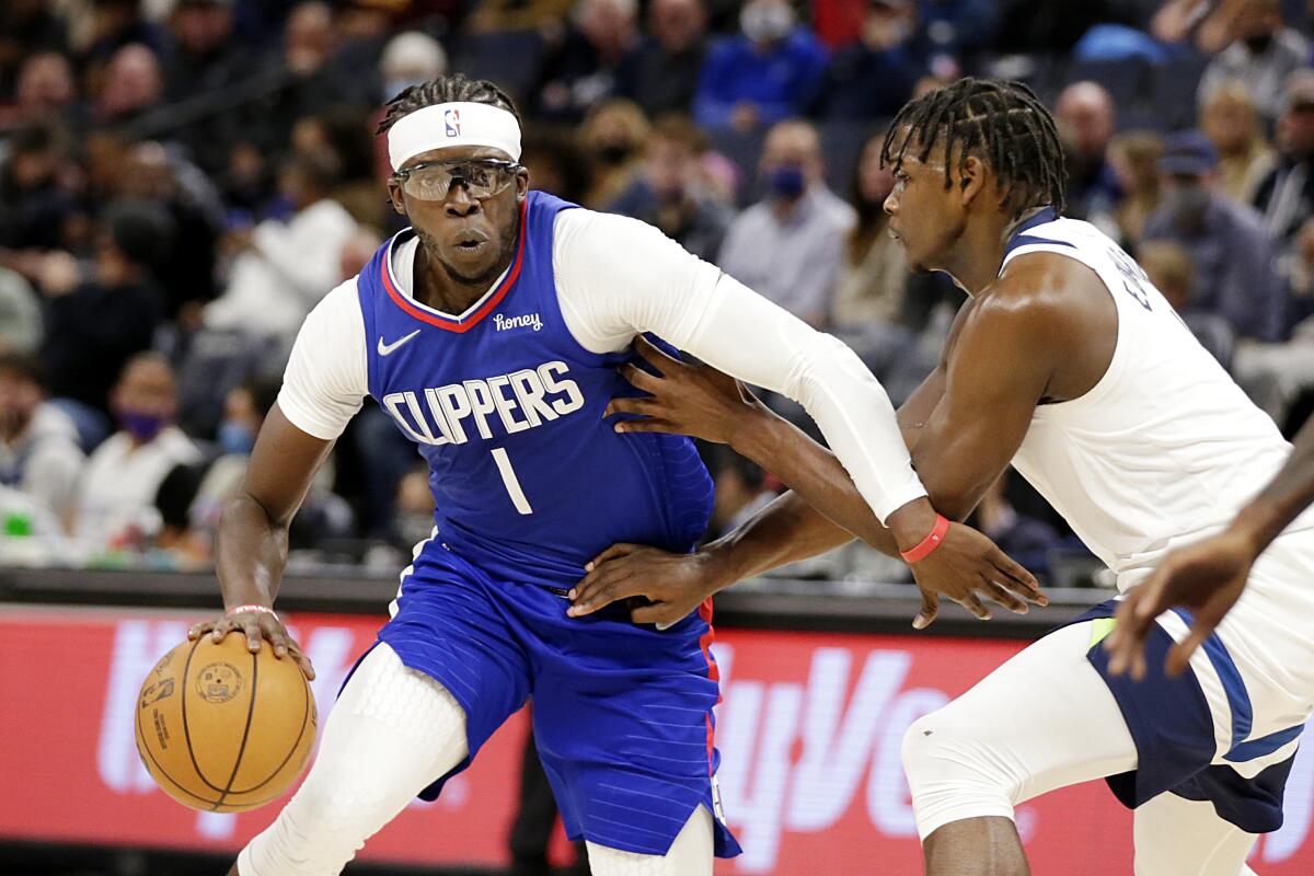 Clippers guard Reggie Jackson drives on Minnesota Timberwolves forward Anthony Edwards.