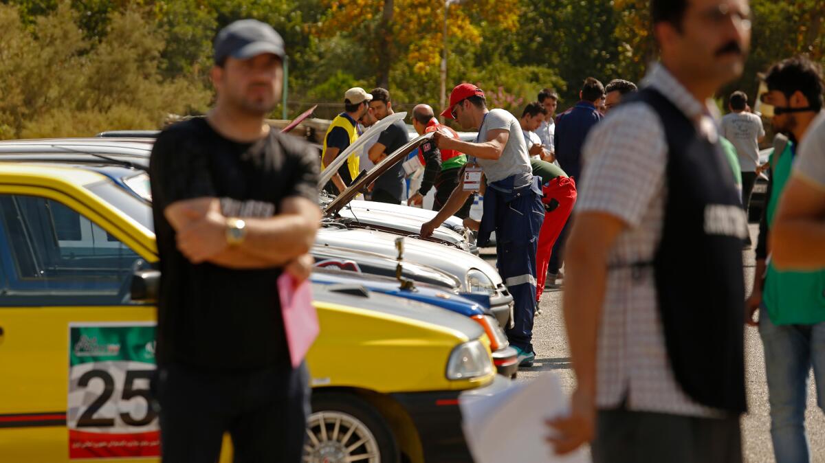 Drivers get their cars inspected before the drag racing begins at a racetrack in Tehran.