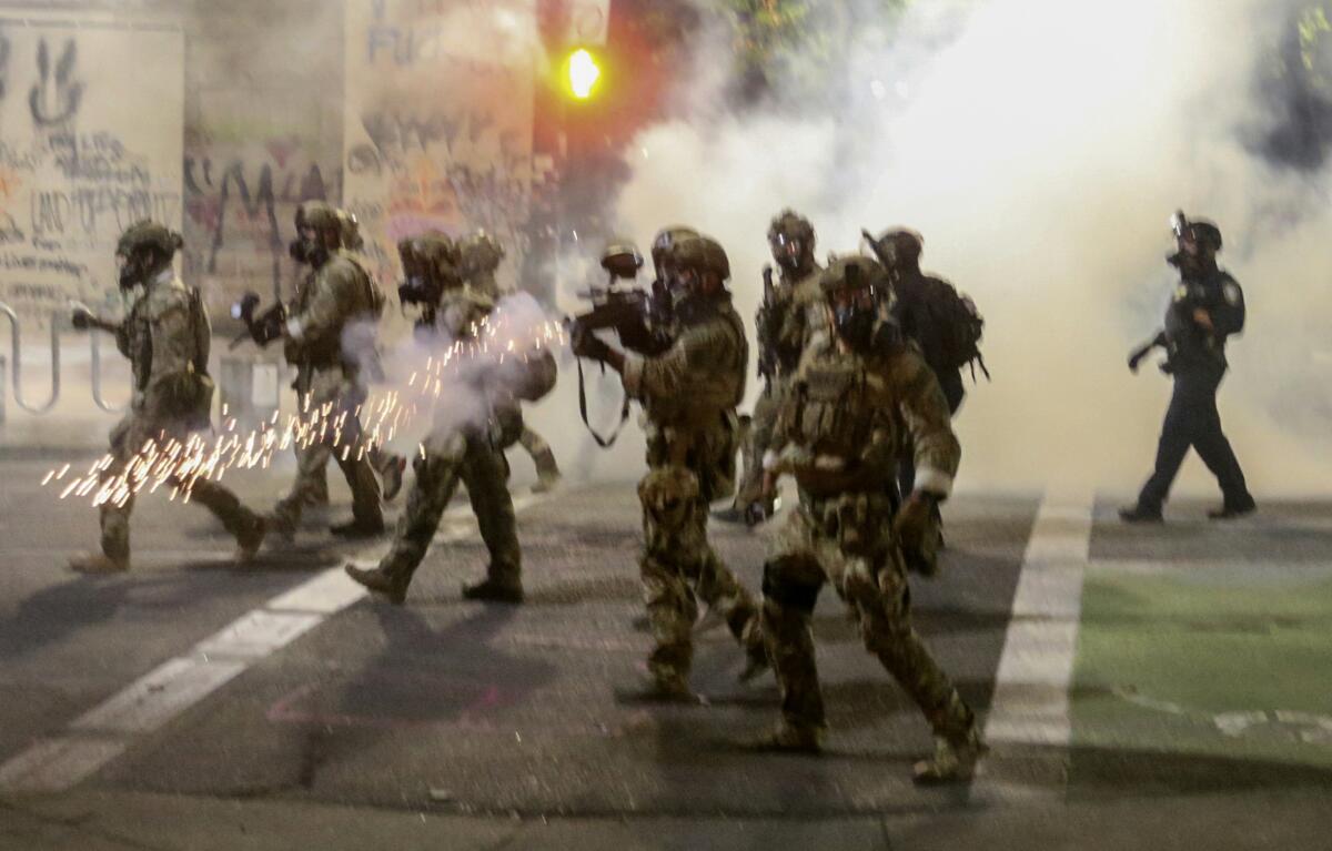 Federal agents fire tear gas and projectiles at protesters in Portland, Ore., on July 17.