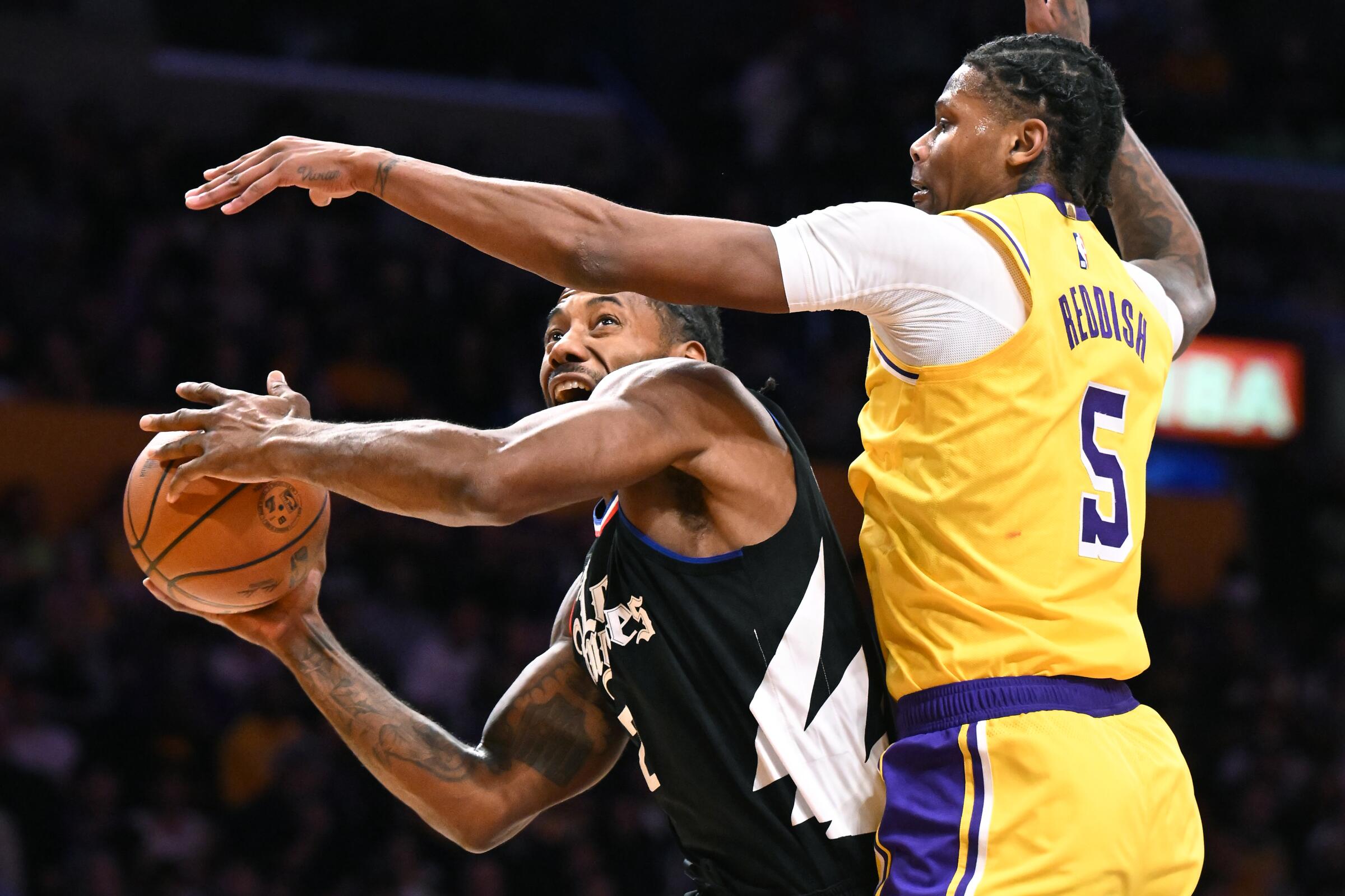 The Clippers' Kawhi Leonard is fouled by the Lakers' Cam Reddish.