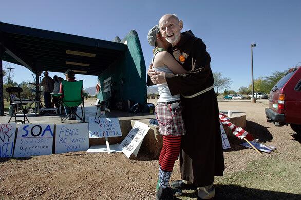 Father Louis Vitale greets activist Mariah Klusmire,19, of Albuquerque before a rally protesting military interrogation training at Ft. Huachuca, Ariz. Klusmire's mother attended events organized by the Franciscan friar before she was born.