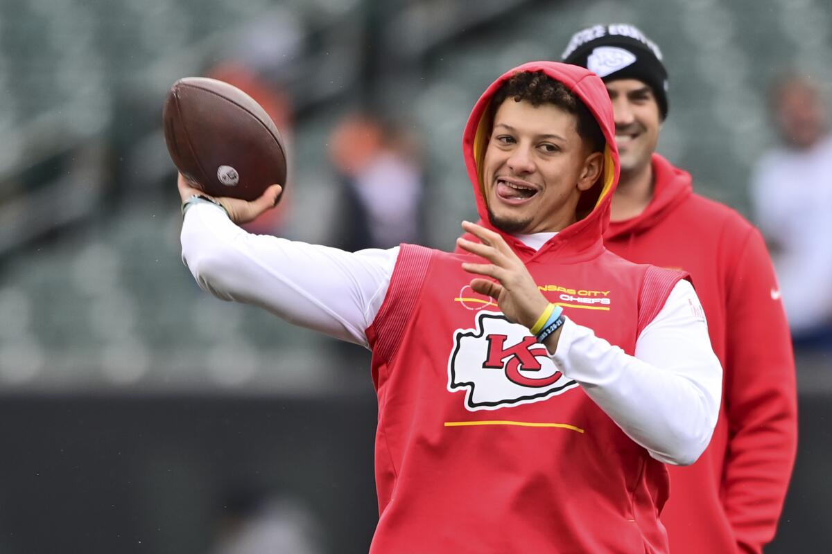 Kansas City Chiefs quarterback Patrick Mahomes sticks out his tongue while throwing during warmups.