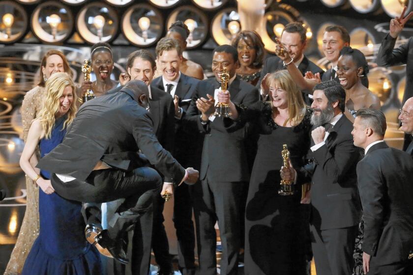"12 Years a Slave" director Steve McQueen leaps into the air as he celebrates with his cast on stage after winning best picture at the 86th Annual Academy Awards on March 2, 2014.