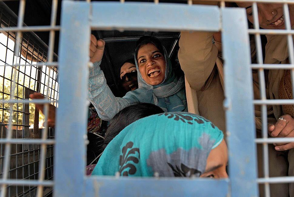 A Kashmiri woman shouts anti-government slogans from inside a police van after being arrested during a protest march.
