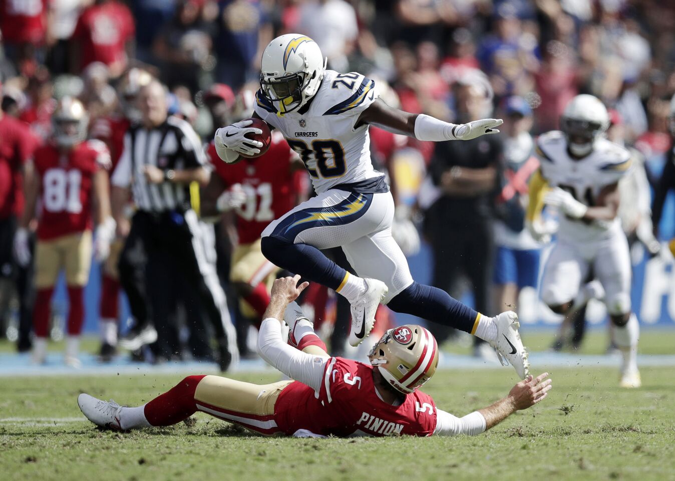 Los Angeles Chargers defensive back Desmond King, top, jumps over San Francisco 49ers punter Bradley Pinion while returning a punt during the first half of an NFL football game, Sunday, Sept. 30, 2018, in Carson, Calif.