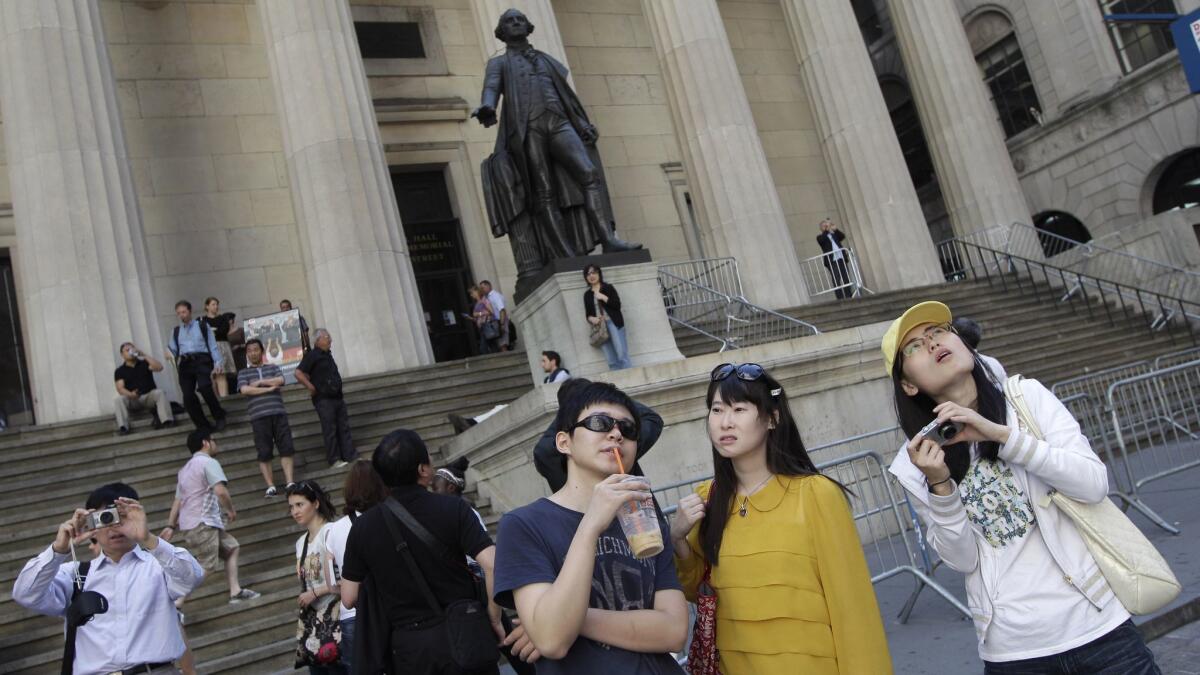 Chinese tourists take in the New York Stock Exchange and Federal Hall National Memorial in 2012.