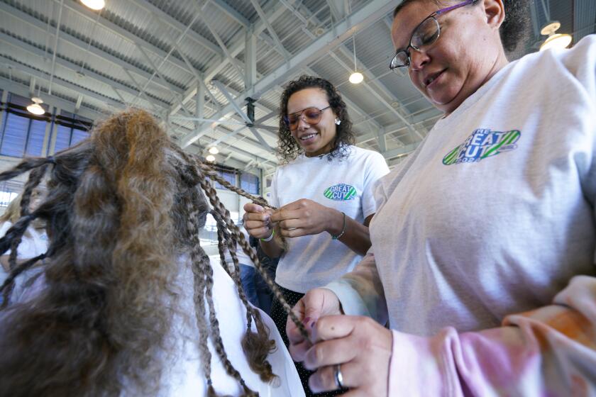 San Diego, CA - March 16: Mahala Smith (l) of Maine worked with her mother, Stephanie Smith (r), as a volunteer at The Great Cut 2024, held at Port Pavilion on Broadway Pier on Saturday, March 16, 2024, in San Diego, CA. Mahala was a two-time recipient of the hair replacement program. (Nelvin C. Cepeda / The San Diego Union-Tribune)