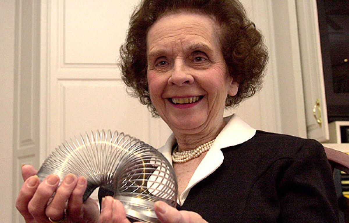 In this 2001 file photo, Betty James, retired president of James Industries, plays with a toy Slinky that made the family company famous in Hollidaysburg, Pa.