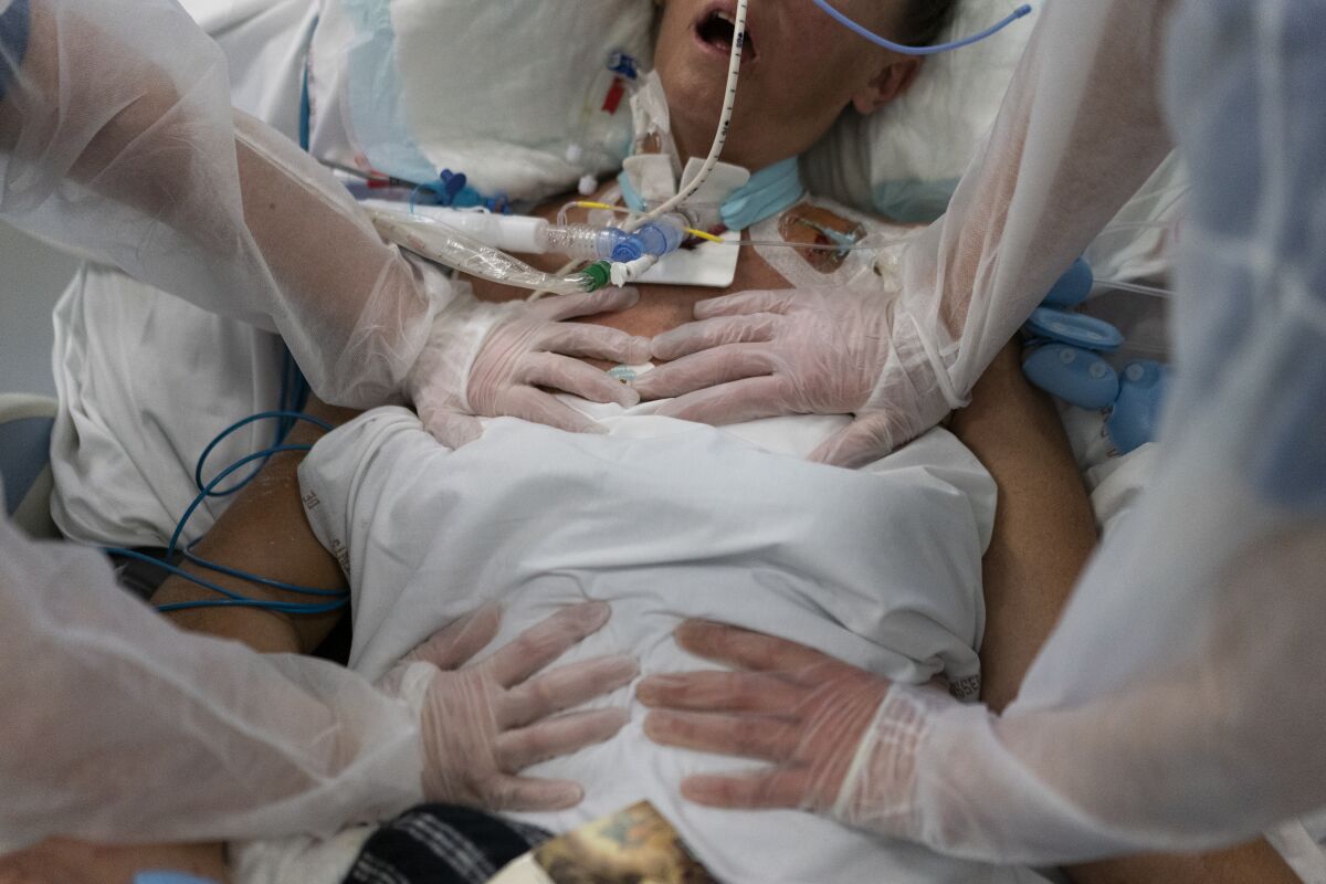 FILE - Nurses perform timed breathing exercises on a COVID-19 patient on a ventilator in the COVID-19 intensive care unit at the la Timone hospital in Marseille, southern France, Friday, Dec. 31, 2021. The official global death toll from COVID-19 is on the verge of eclipsing 6 million — underscoring that the pandemic, now in its third year, is far from over. (AP Photo/Daniel Cole, File)