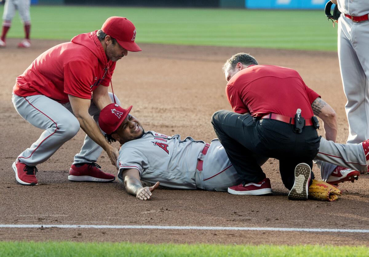 Angels pitcher Felix Pena lays on the ground grimacing.