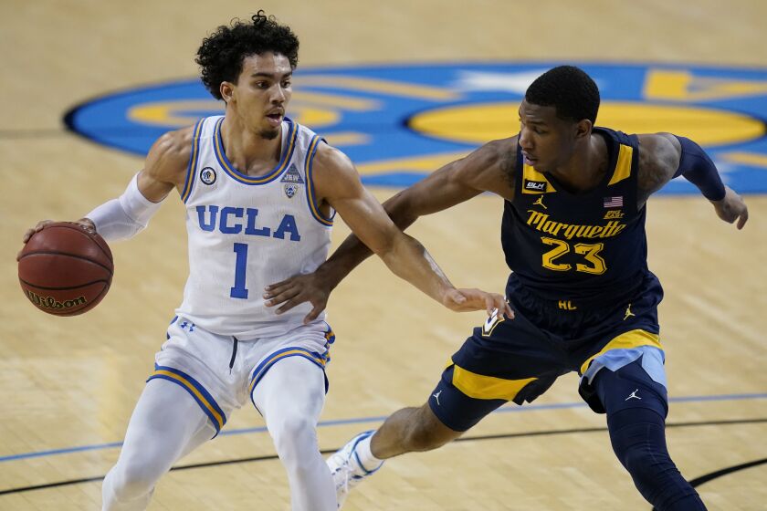 UCLA guard Jules Bernard, left, is defended by Marquette forward Jamal Cain during the second half.