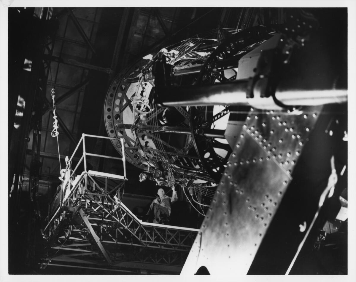 Edwin P. Hubble seated on the Newtonian platform of the Hooker 100-inch reflecting telescope, as viewed from the dome floor, circa 1940.