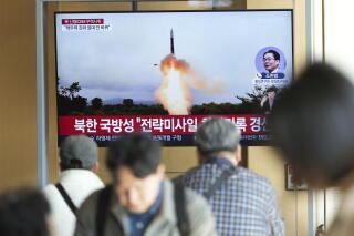 A TV screen shows an image of North Korea's an intercontinental ballistic miss