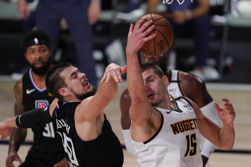 The Clippers' Ivica Zubac, left, battles the Nuggets' Nikola Jokic for a rebound Sept. 5, 2020.