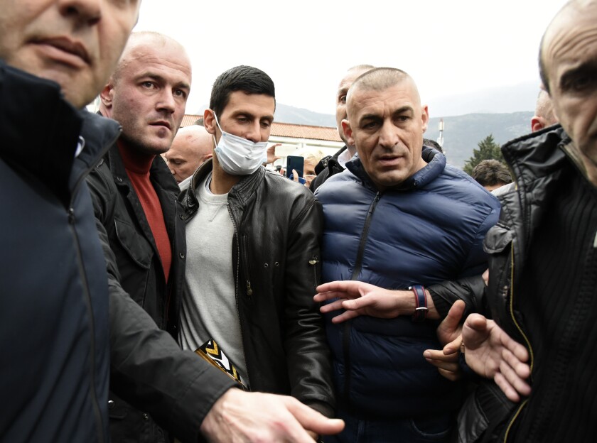 Novak Djokovic (centro) al ingrear al ayuntamiento de Budva en Montenegro, el viernes 28 de enero de 2022. (AP Foto/Risto Bozovic)