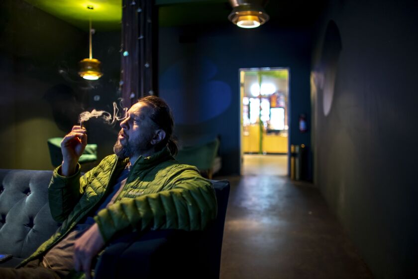 PALM SPRINGS, CA - JANUARY 31, 2023: Shannon Graham smokes marijuana inside the lounge at Reefer Madness on January 31, 2023 in Palm Springs, California. (Gina Ferazzi / Los Angeles Times)