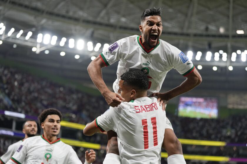 Morocco's Yahya Jabrane, top, celebrates with Abdelhamid Sabiri (11) after Sabiri scored a goal during the World Cup group F soccer match between Belgium and Morocco, at the Al Thumama Stadium in Doha, Qatar, Sunday, Nov. 27, 2022. (AP Photo/Frank Augstein)