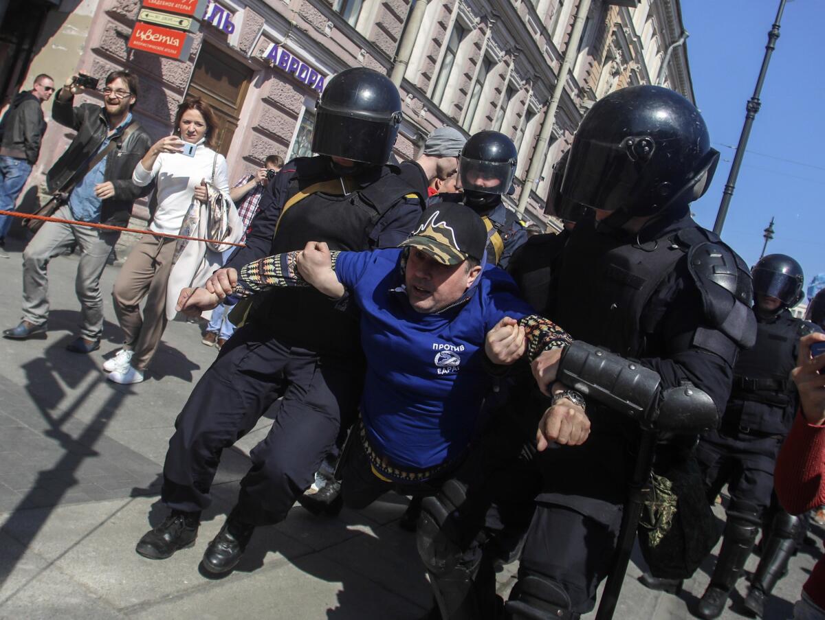Riot police officers detain protesters marching through central St. Petersburg carrying placards saying "Putin is not immortal" in reference to President Vladimir Putin who has been at the helm of the country since 2000. (Dmitry Yermakov / Associated Press)