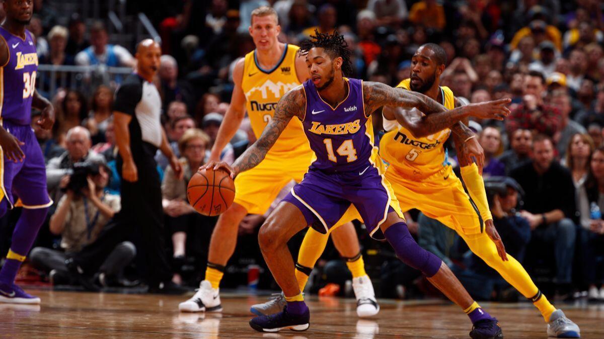 Lakers forward Brandon Ingram (14) works against Denver Nuggets guard Will Barton (5) in the second half of a game on Saturday.