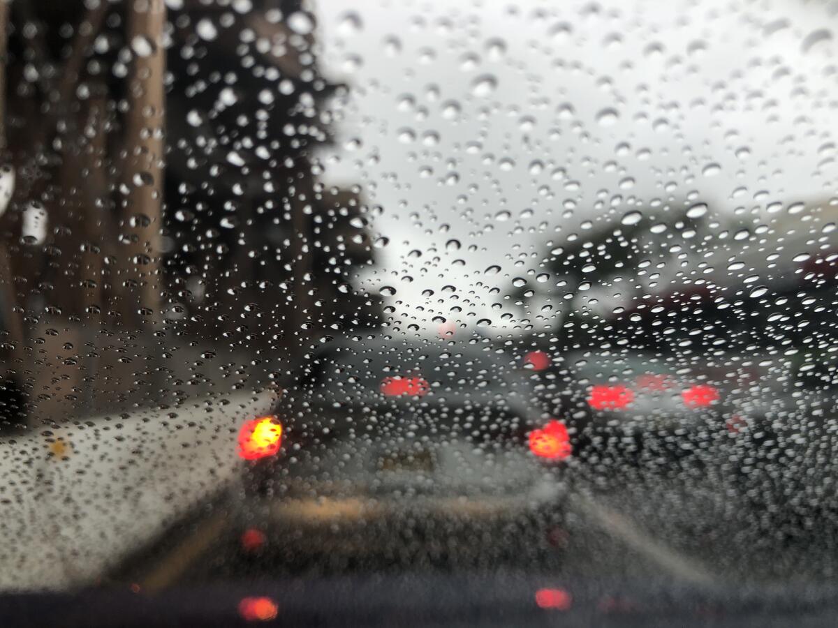 Rain covers the windshield of a car in traffic earlier this year.