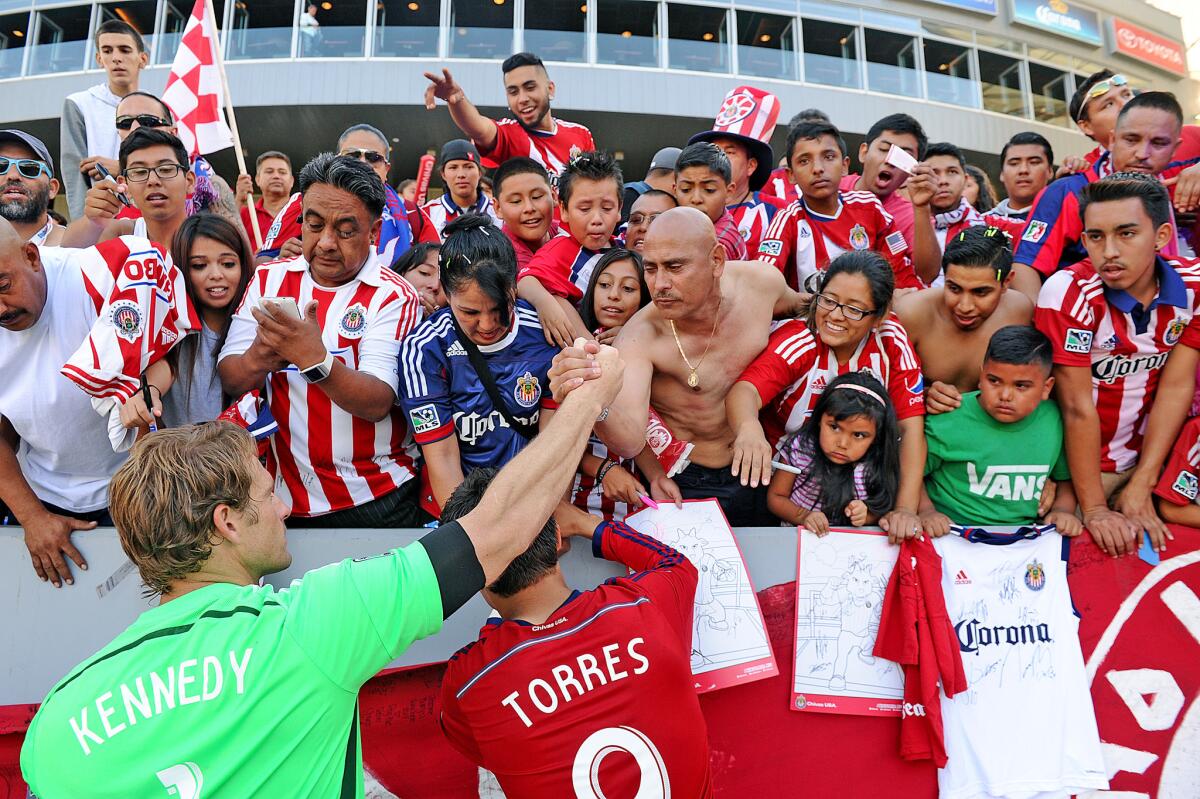 Chivas players Dan Kennedy, left, and Erick Torres pay their respects to the fans on Oct. 26, 2014, after the team's final game in Carson.