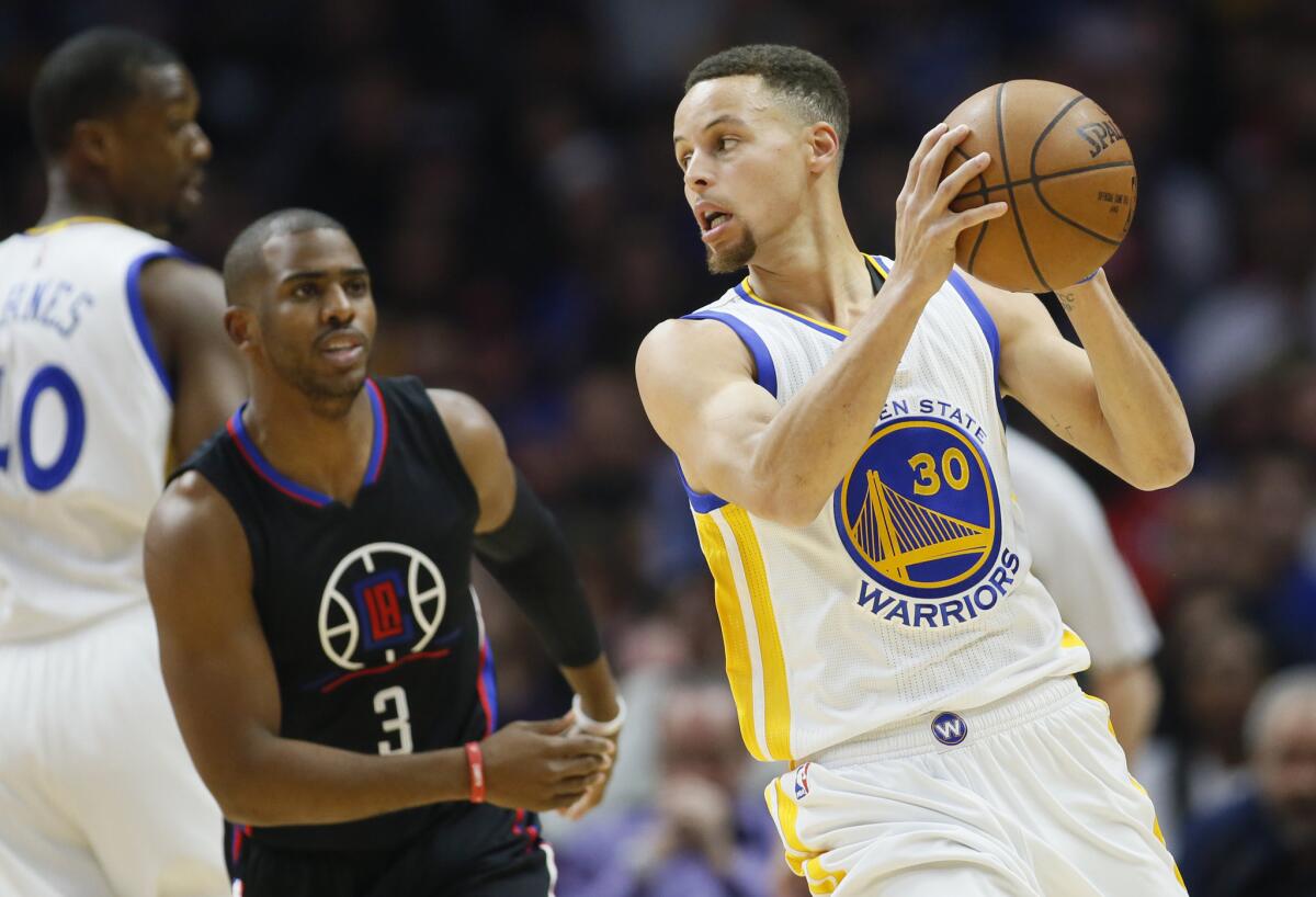 Warriors guard Stephen Curry is defended by Clippers guard Chris Paul during the first half of a game on Feb. 20.