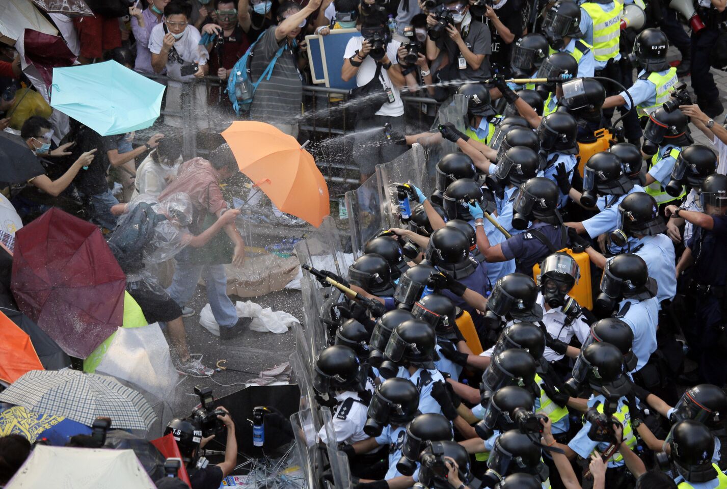 Riot police use pepper spray against protesters after thousands of people blocked a main road to the financial central district in Hong Kong on Sept. 28.