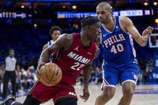 Jimmy Butler del Heat de Miami avanza hacia la canasta con el balón frente a Nicolas Batum de los 76ers de Filadelfia en el juego del mini-torneo de la NBA el miércoles 17 de abril del 2024. (AP Foto/Chris Szagola)