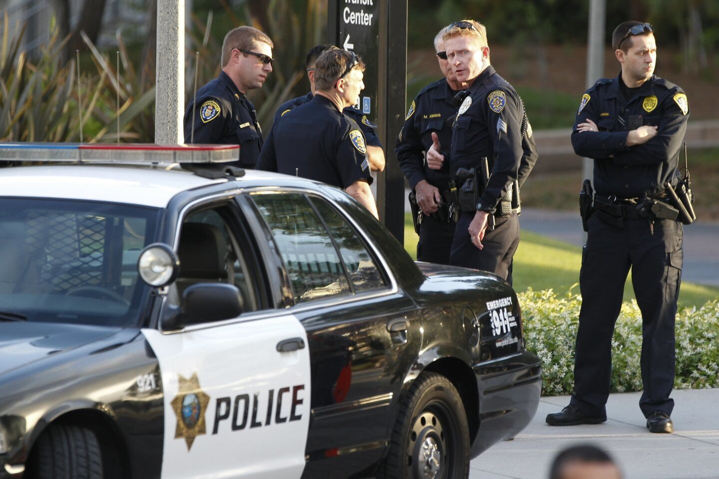 San Diego policeman stand nearby a protest by students upset about the SDSU president's response to anti Muslim flier.