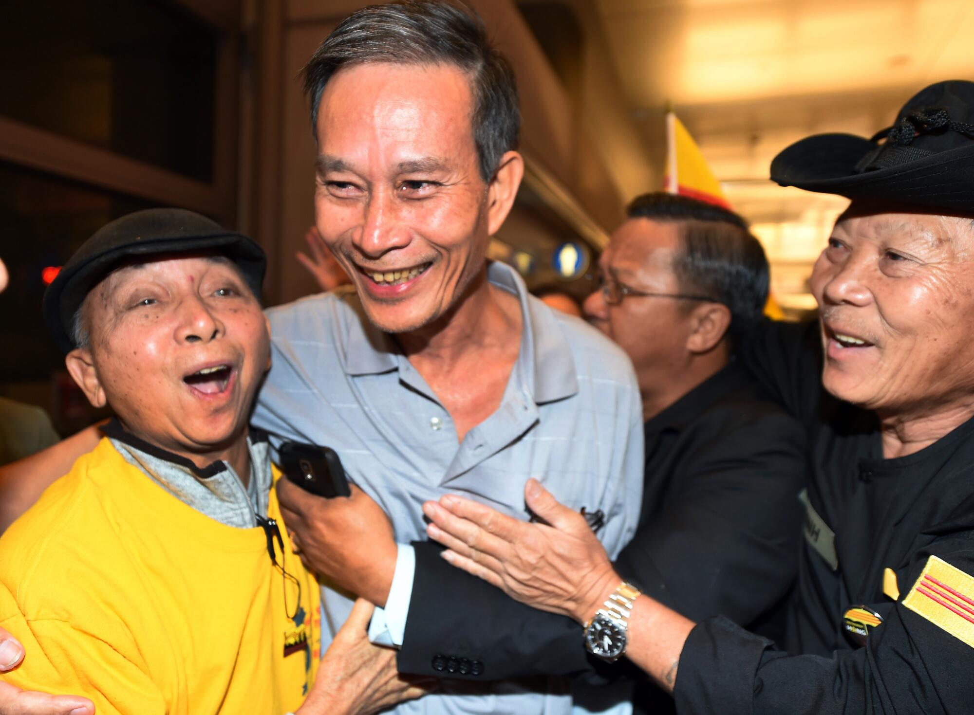 Freed Vietnamese dissident Nguyen Van Hai, center, is greeted upon arrival at LAX in 2014.