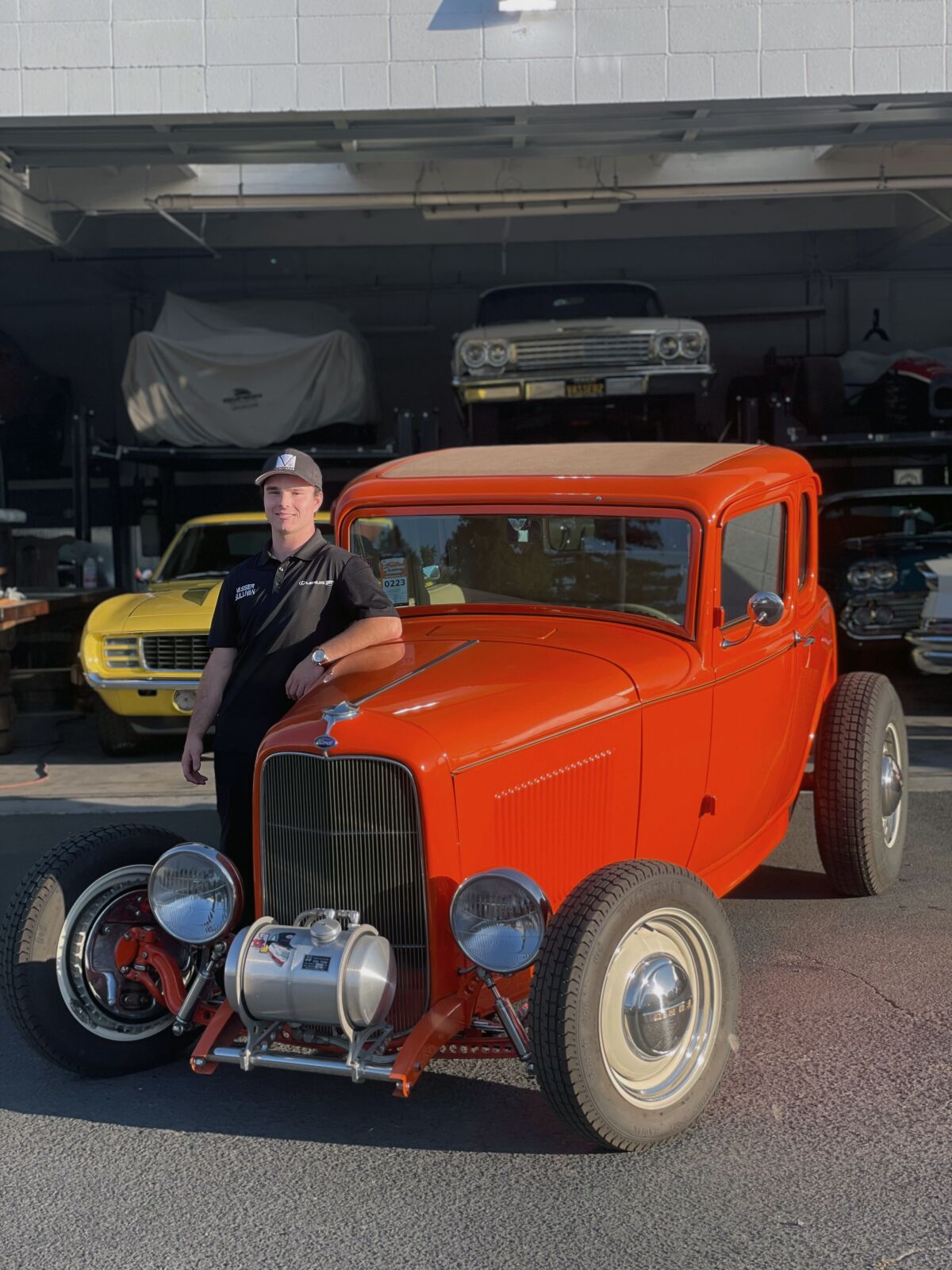 This August 2020 photo shows Cole Kleis standing next to a 1932 Ford Coup in front of a garage of old cars he’s been restoring with his family in Napa, Calif. Automakers are facing a challenge with the newest generation of drivers — teens of today aren't in a hurry to get their first car let alone a drivers license. There are exceptions to the theory that teens don't care about cars, including 20-year-old Cole Kleis of Napa, California. Kleis attends Colorado State University at Pueblo, majoring in automotive industry management. He took his first job in a dealership at age 12 cleaning cars, sweeping floors and helping in the parts department. (AP Photo/Jenna Fryer)
