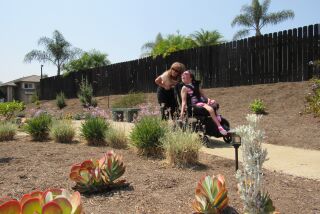 Patricia Wood and her daughter, Kimberly, pause to take in the award-winning garden at their home in unincorporated El Cajon.