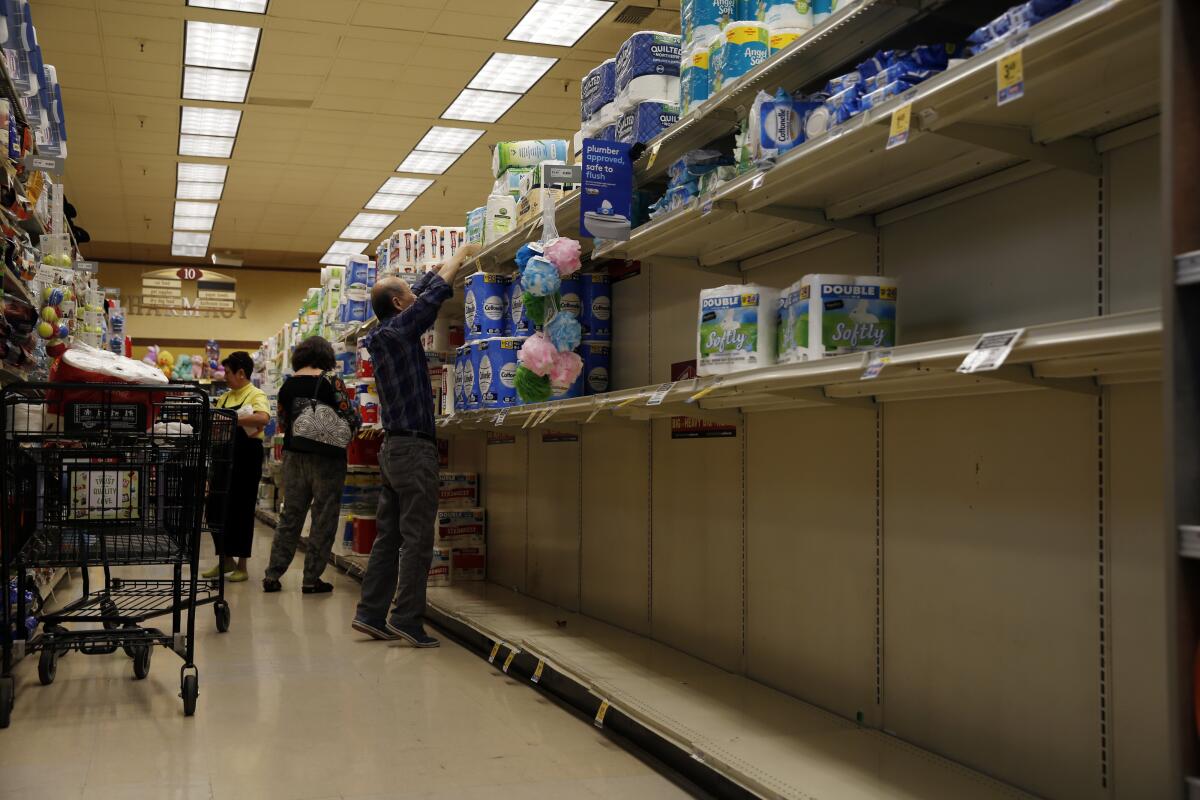 Shelves with toilet paper and disinfecting wipes are nearly empty at a Pavilions supermarket in South Pasadena on March 11.