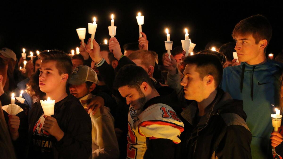 People gather in Benton, Ky., on Thursday night for a vigil honoring the victims of a fatal shooting at Marshall County High School.