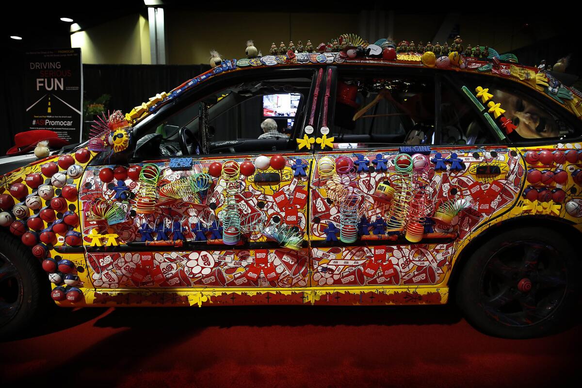 Dawn Shurmaitis, public relations manager for the Advertising Specialty Institute, covered this Mazda Protege with logoed magnets, Slinkys, dolls, pens and other promotional items. It left Monday on a 2,700-mile journey across 12 states.