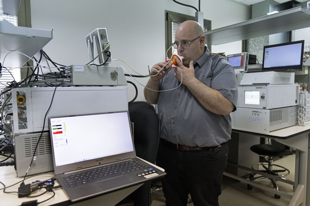 Israeli Harel Hershtik, vice president of strategy and technology at Scentech Medical, demonstrates his company's product, which he says can detect certain diseases by analysing a patient's breath, at the company's office in Rehovet, Israel, May 3, 2022. When he was 20 years old, Hershtik planned and executed a murder, shooting his victim in the head and burying the body in a crime that a quarter of a century later is still widely remembered for its grisly details. Today, he is the brains behind an Israeli health-tech startup with the backing of prominent public figures and deep-pocketed investors. (AP Photo/Tsafrir Abayov)