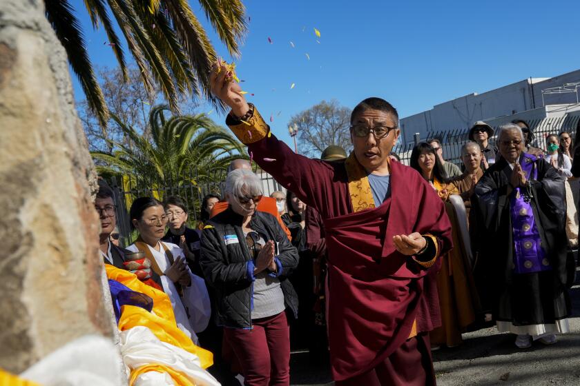 Khenpo Paljor, a Tibetan lama from Des Moines, Iowa, leads a prayer at the Birthplace of Antioch marker, Saturday, March 16, 2024, in Antioch, Calif. Participants of the event titled “May We Gather” placed traditional Tibetan scarves on the marker as they prayed for peace and harmony. (AP Photo/Godofredo A. Vasquez)