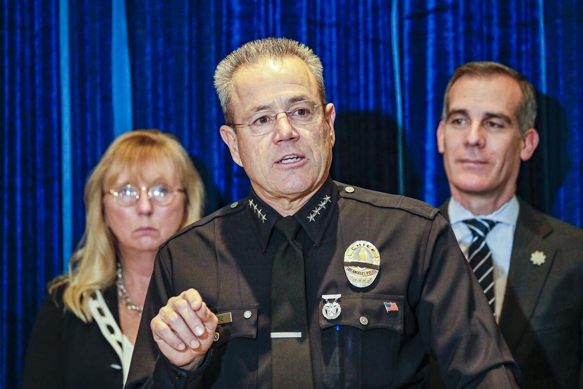 LAPD Chief Michel Moore speaks at a news conference flanked by Eileen Decker, president of the L.A. Police Commission, and Mayor Eric Garcetti.