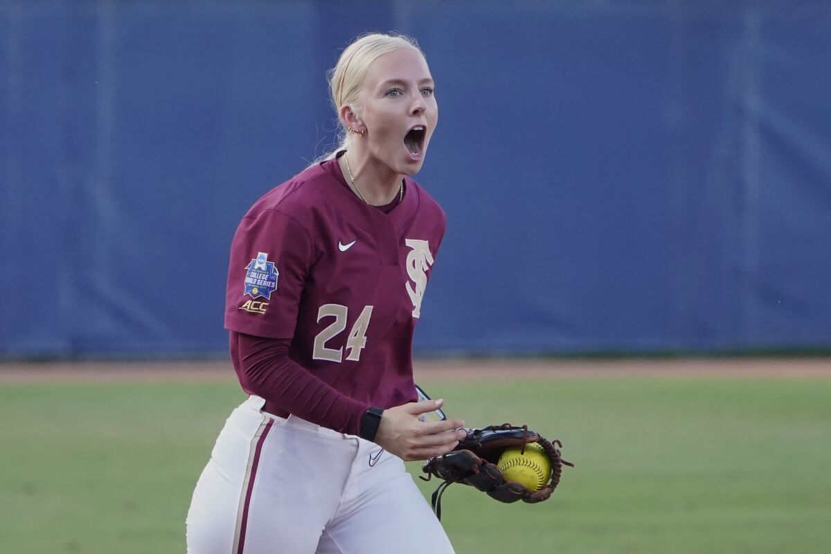 Florida State's Sydney Sherrill (24) reacts after tagging out Oklahoma's Nicole Mendes at third base in the second inning of the first game of the NCAA Women's College World Series softball championship series Tuesday, June 8, 2021, in Oklahoma City. (AP Photo/Sue Ogrocki)