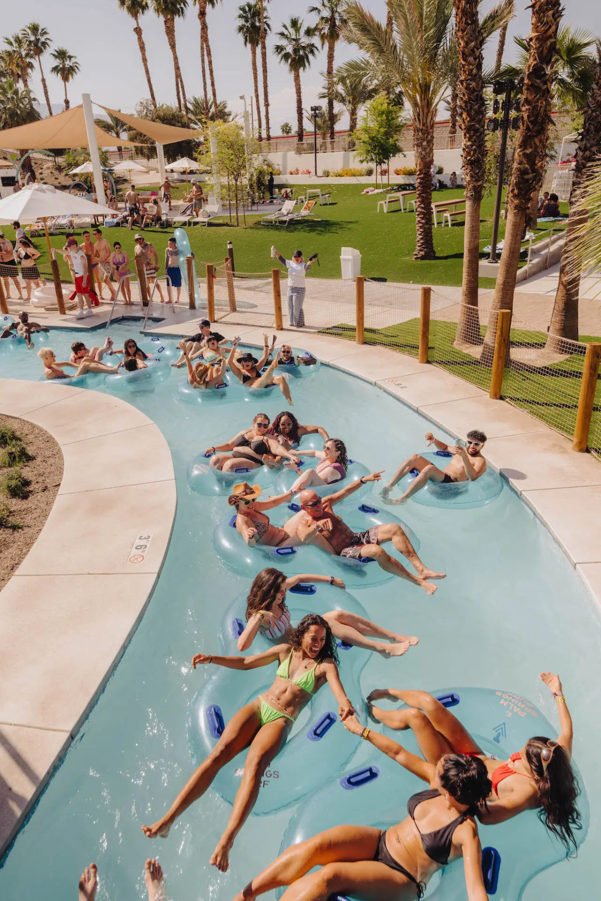 People on inner tubes float down a lazy river at the Palm Springs Surf Club.