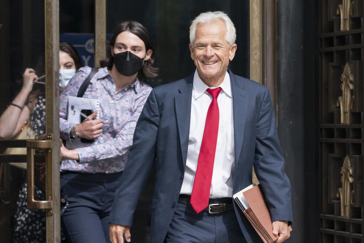 Former Trump White House official Peter Navarro smiles as he leaves federal court.